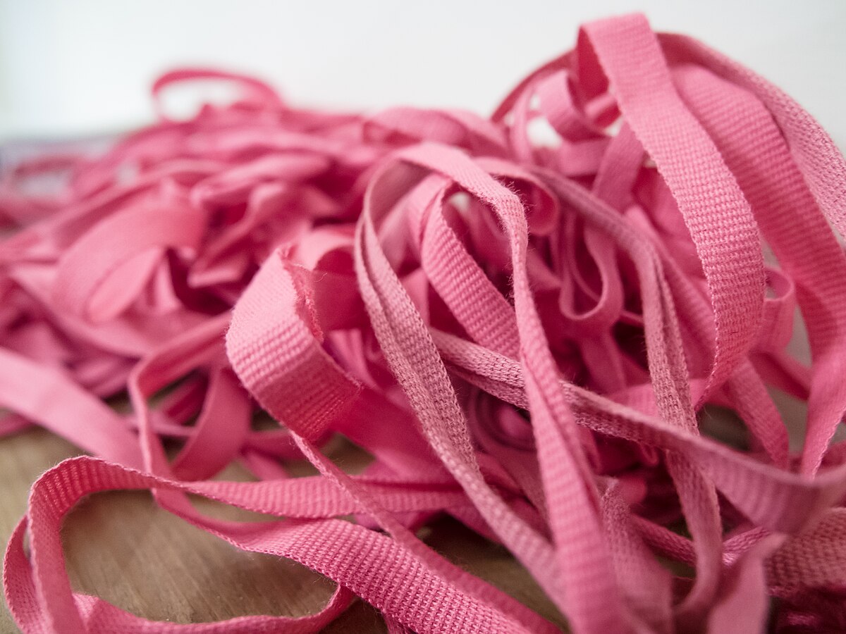 A bundle of documents tied with red tape, symbolizing bureaucratic barriers to plug-in solar in Alberta